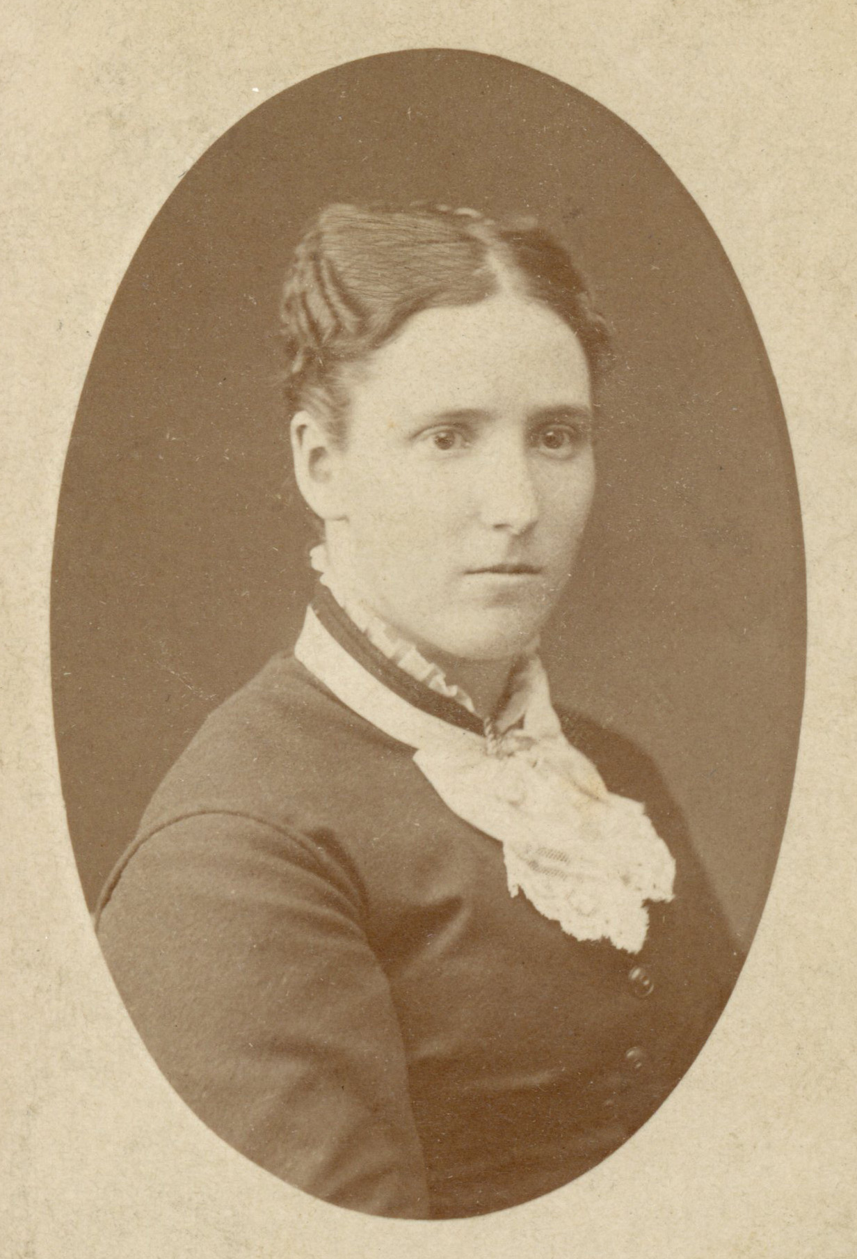 Sepia photo of a woman with dark hair, light skin and a dark dress.